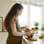 a pregnant woman preparing food on the kitchen counter