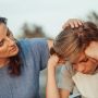 woman in blue shirt talking to a young man in white shirt