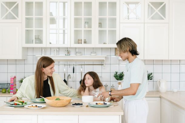 men talking to their daughter inside the kitchen