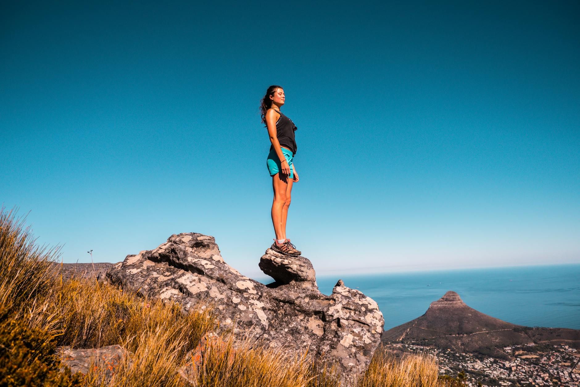 woman in black top and blue shorts on stone under blue sky woman in black top and blue shorts on stone under blue sky woman in black top and blue shorts on stone under blue sky woman in black top and blue shorts on stone under blue sky woman in black top and blue shorts on stone under blue sky woman in black top and blue shorts on stone under blue sky